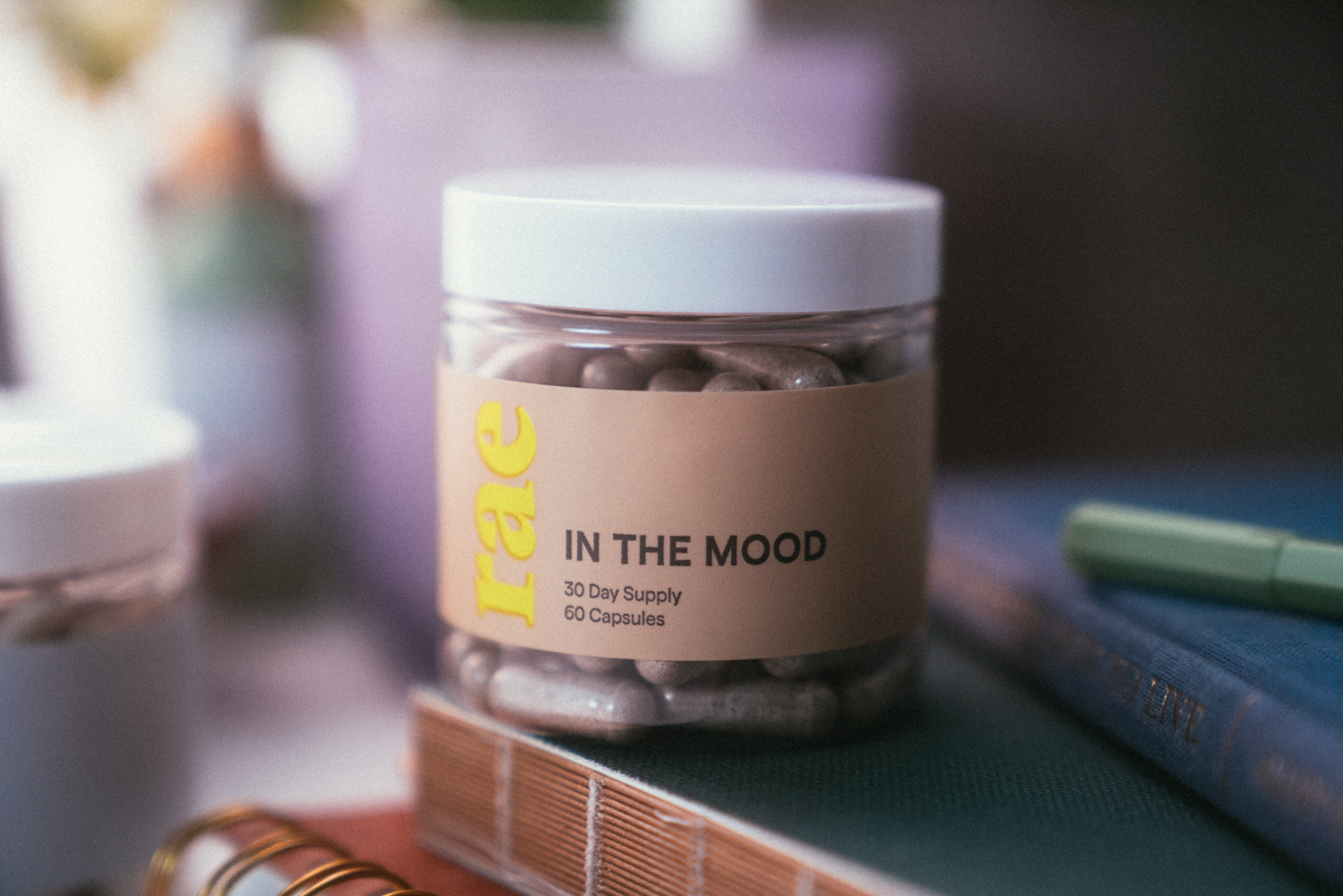 A jar of In The Mood supplement pills sits on a stack of books.