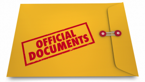 A yellow folder with a red stamp that says 'Official Documents' with a rubber band around it.