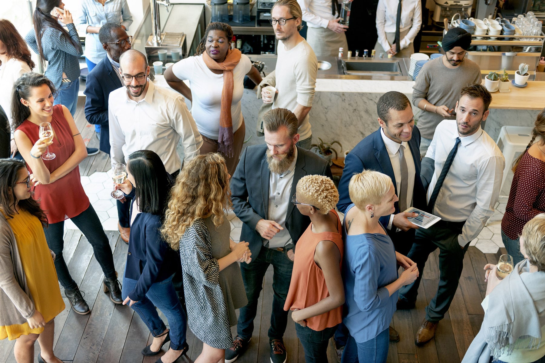 A group of diverse business professionals networking and socializing at an industry event.