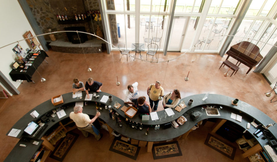 An俯瞰图显示了一群人在一家葡萄酒厂的柜台前品尝葡萄酒。