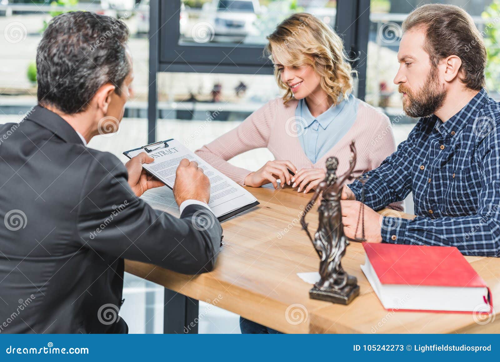 A couple is sitting at a table discussing financial responsibilities with a financial advisor.