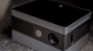 A black and silver HP projector sits on a carpeted surface.
